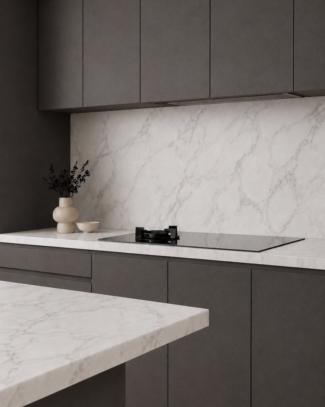 Charcoal cabinetry and marble-look surfaces renewed with Renuva architectural film